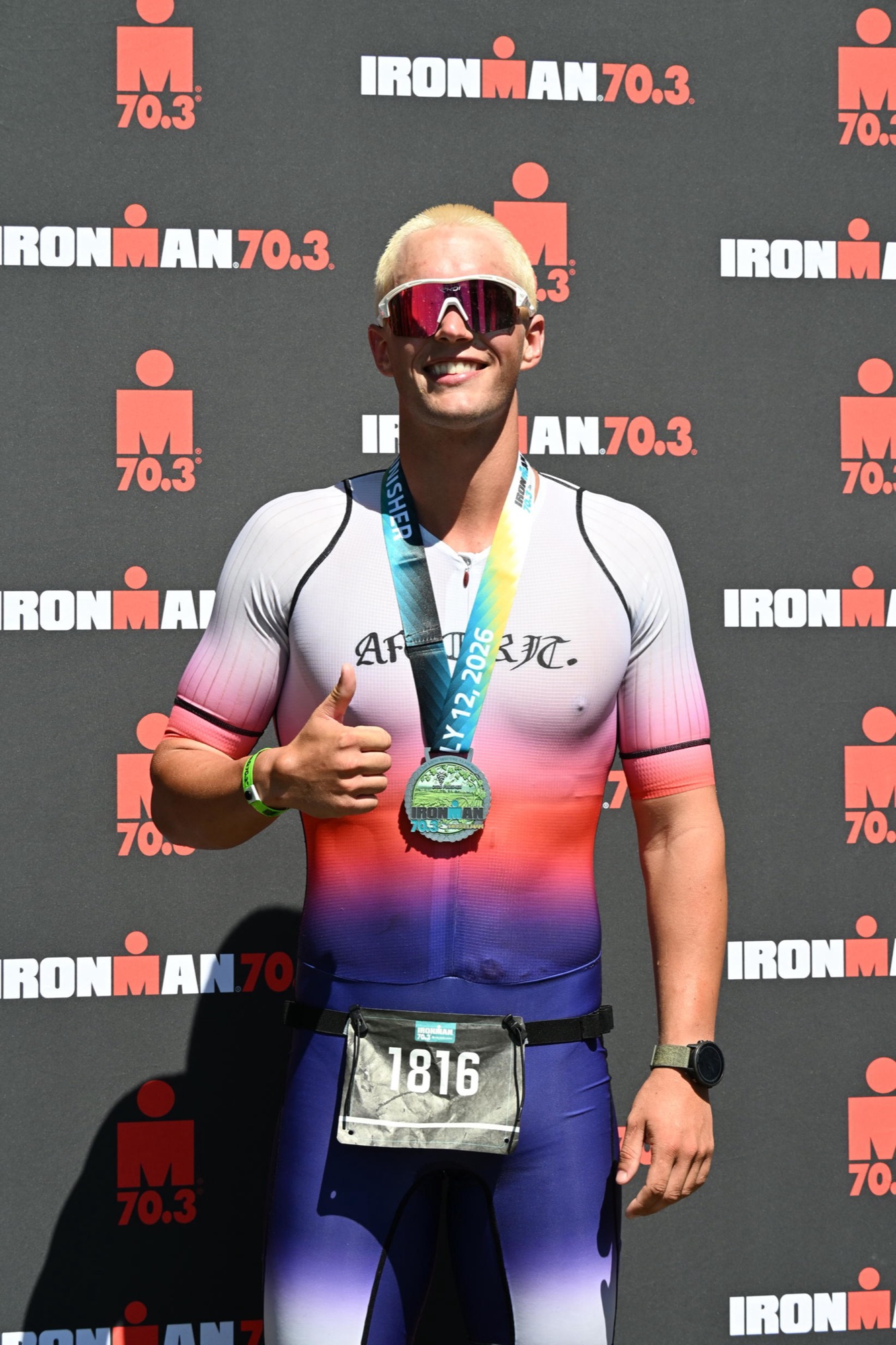 Thumbs up with a 70.3 finisher medal