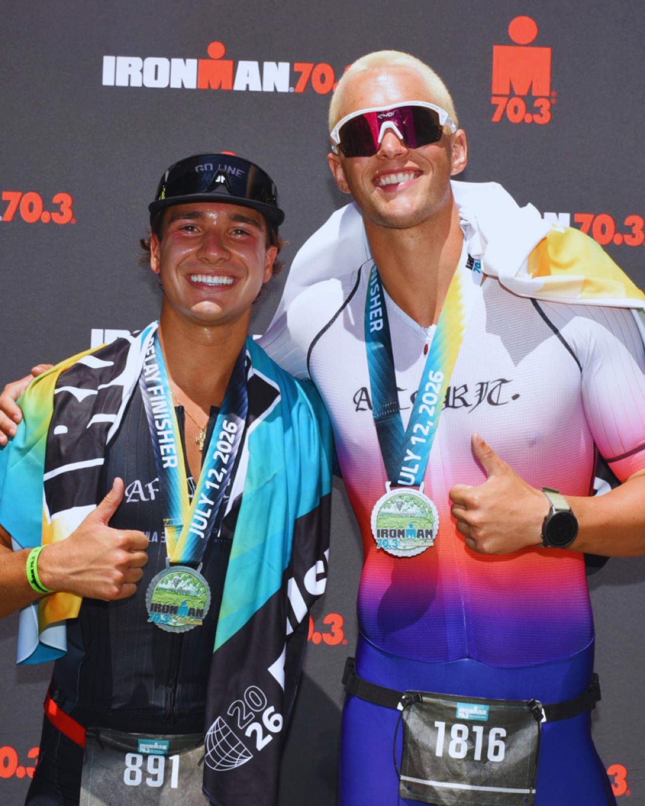 Patrick with one of his athletes, both holding 70.3 finisher medals